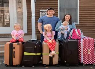 A family standing next to their luggage

Description automatically generated with low confidence